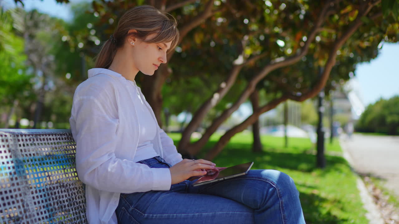 Woman Using Tablet in Park