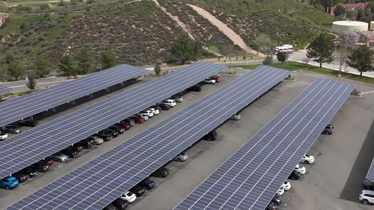 Konstrukcja parkingu z panelami słonecznymi, zrównoważona energia – ujęcie z lotu ptaka wznoszące się