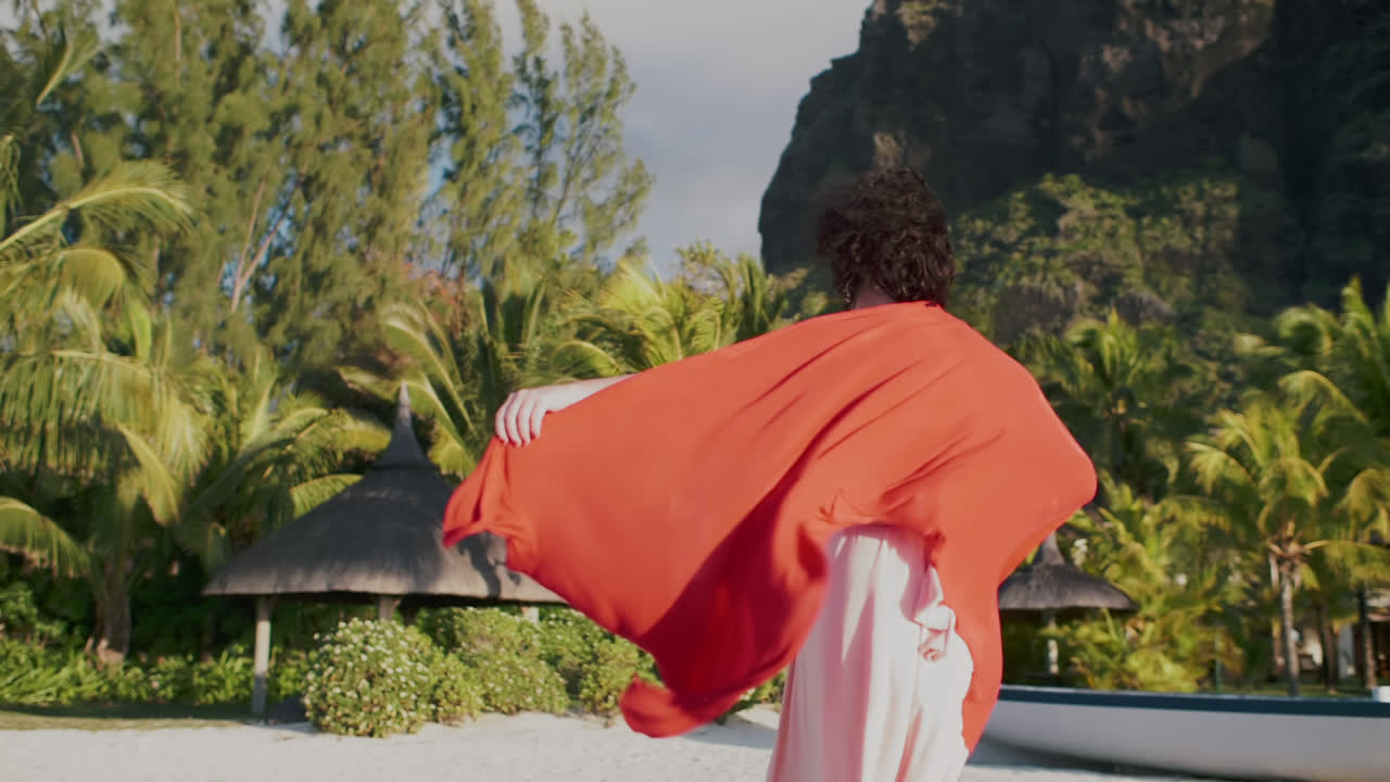 Woman Dancing with Flowing Red Fabric on a Tropical Beach