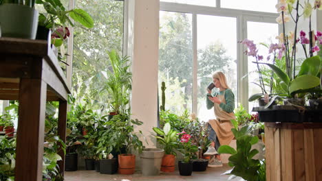 mujer disfrutando de una pausa para el café en una tienda de plantas