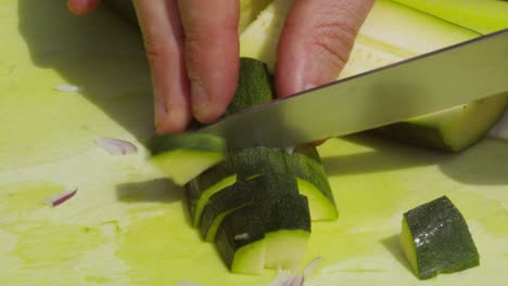 male hands cutting organic healthy courgette zucchini outside on chopping board - 4k slow motion meal food preparation clip