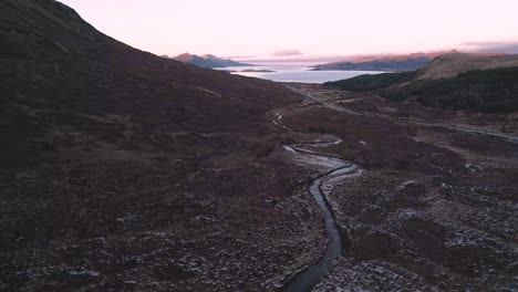 Zerklüftetes-Gelände-Auf-Der-Insel-Skye-In-Der-Abenddämmerung,-Hervorhebung-Gewundener-Bäche-Und-Entfernter-Berge,-Luftaufnahme