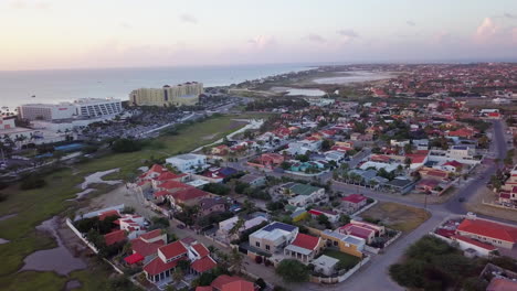 residential neighborhoods behind massive hotels along the coast of aruba during golden hour