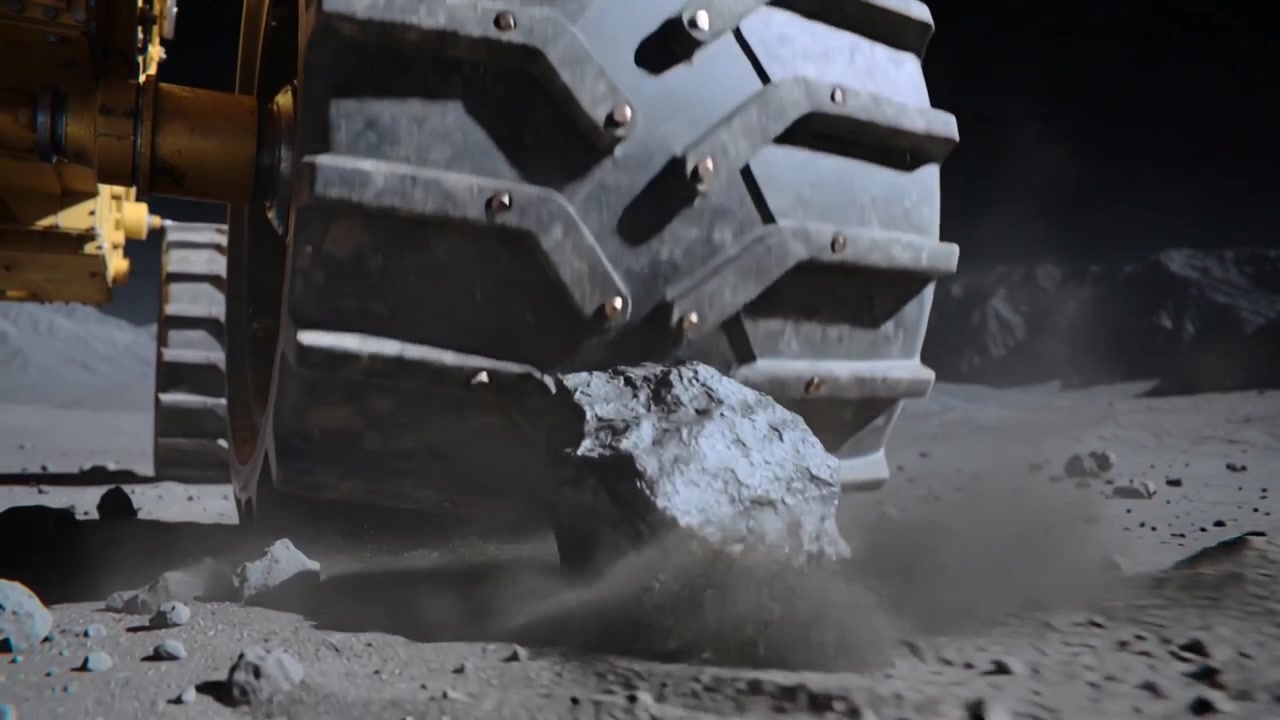 Rolling large tire contacting rock and pushing it under tread on moonscape plain, exposing bolts