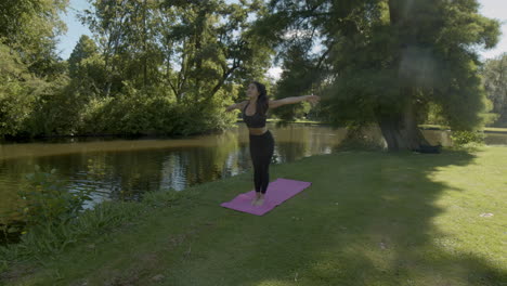 woman starting serie of yoga exercises in beautiful park