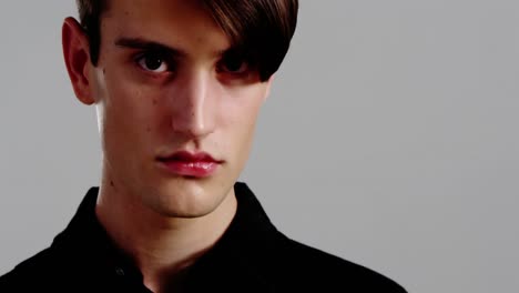 androgynous man posing against grey background