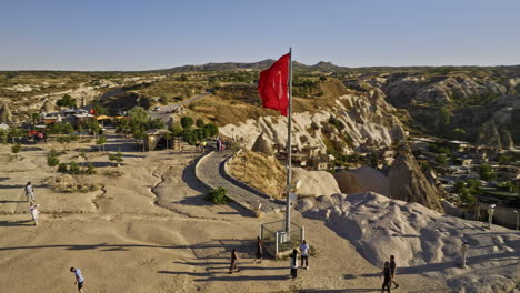 göreme turkey aerial v18 low fly around turkish flag on high plateau view point capturing panoramic view of ancient cave town and landscape of rock formations - shot with mavic 3 cine - july 2022