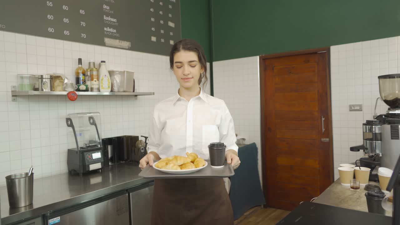 retrato de una mujer barista sonriente de oriente medio. gente en delantal sirviendo una taza de café y croissants. orden de pan en un café. casiera de un restaurante. camarera en una cafetería. estilo de vida de la gente. servicio de negocios.
