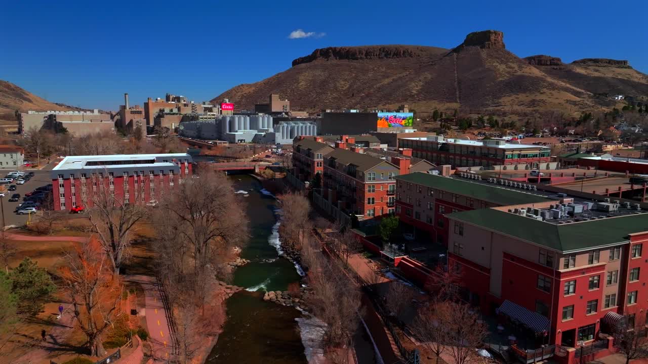 Historic downtown Golden Colorado aerial drone Clear Creek River North Table Mountain Coors Beer Factory Golden Gate Canyon winter sunny morning afternoon blue sky businesses buildings forward pan