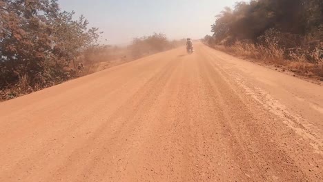 Lapso-De-Tiempo-De-La-Moto-En-El-Frente-En-El-Camino-De-Tierra-Con-Una-Nube-De-Polvo-Masiva-Que-Viene-De-Detrás