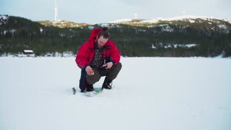 Man-Is-Fixing-His-Ice-Angler-In-A-Frozen-Lake