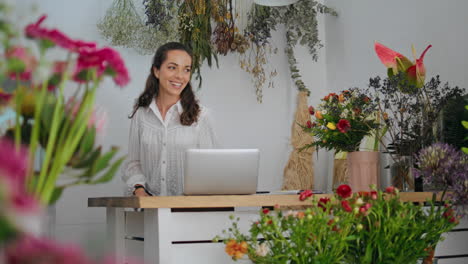 la mujer florista de bienvenida trabaja en la tienda de flores. feliz dueño del negocio sonriendo.