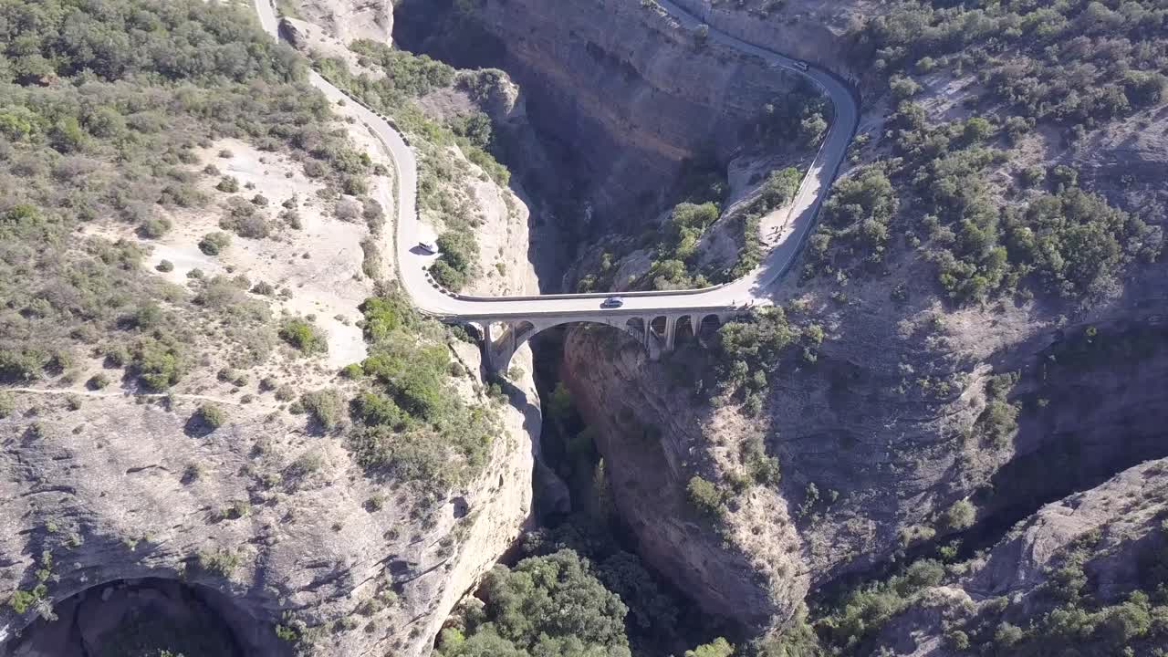 스페인의 아름다운 산길을 따라 다리 위를 운전하는 자동차의 공중 전망
