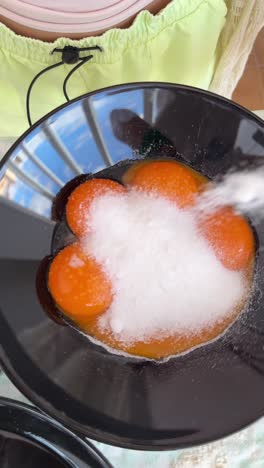 preparing egg yolks with sugar for a dessert
