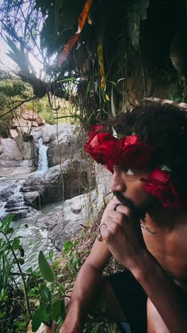 man with rose crown by a waterfall