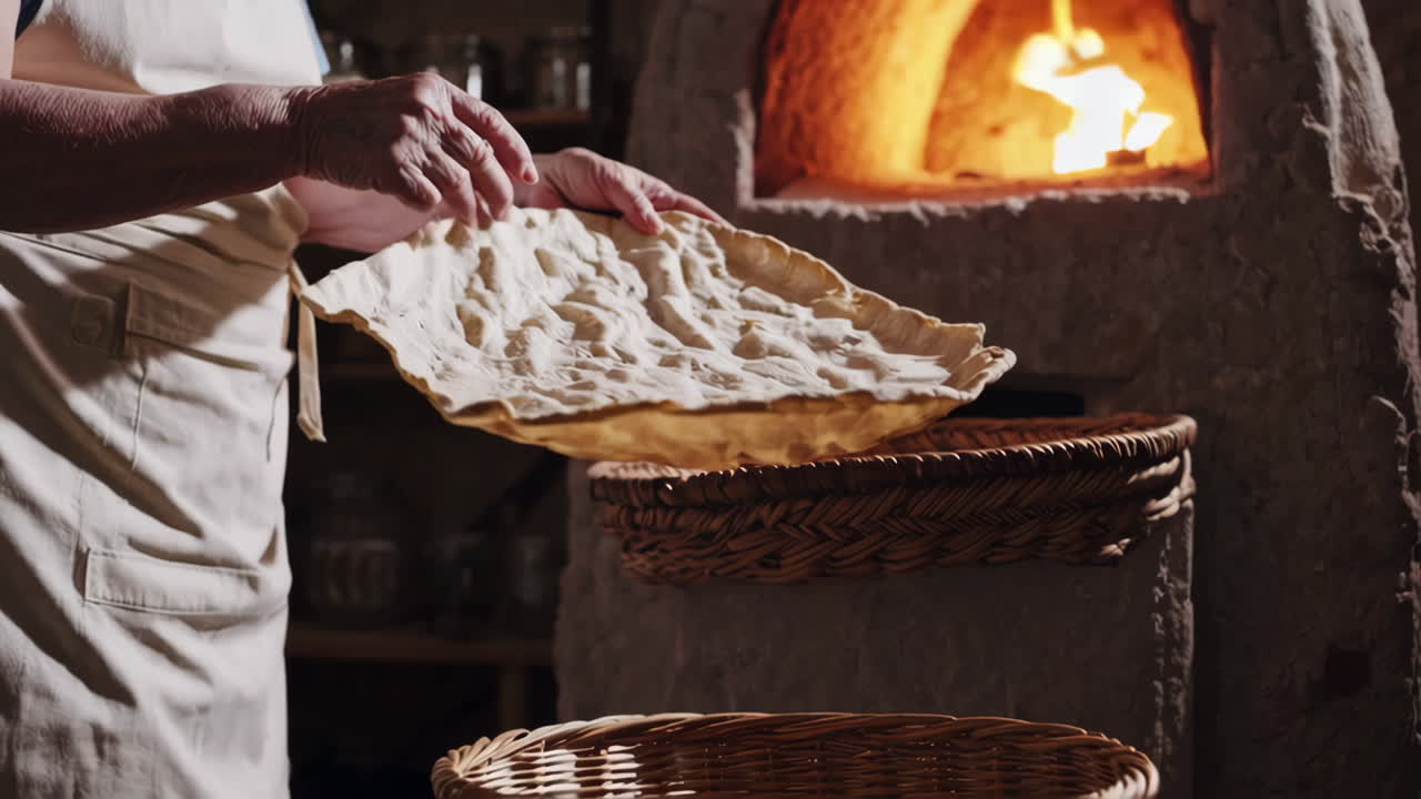 Woman baking bread in a wood-fired oven