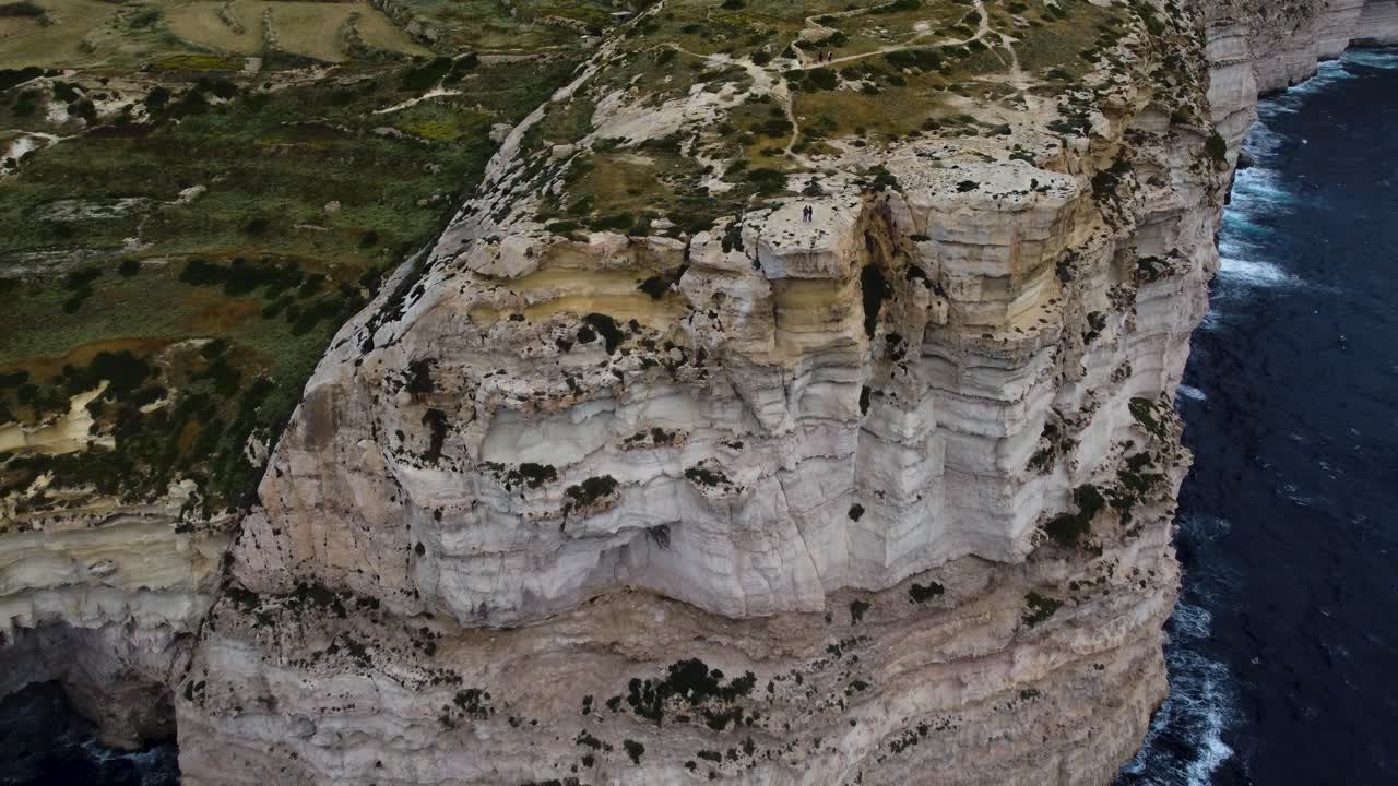 costa rocosa línea de costa acantilada cerca del mar océano, vegetación verde, plantas de flores en las tierras altas, piedra caliza vista general aérea tomada por dron
