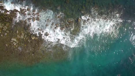 vista dall'alto di un frangiflutti roccioso e delle onde che si infrangono contro di esso