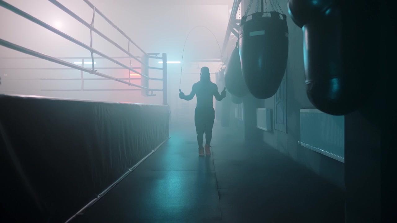 Boxer Silhouette Skipping Rope in a Dramatic Gym