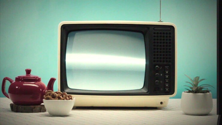Televisor retro con aperitivos y tetera