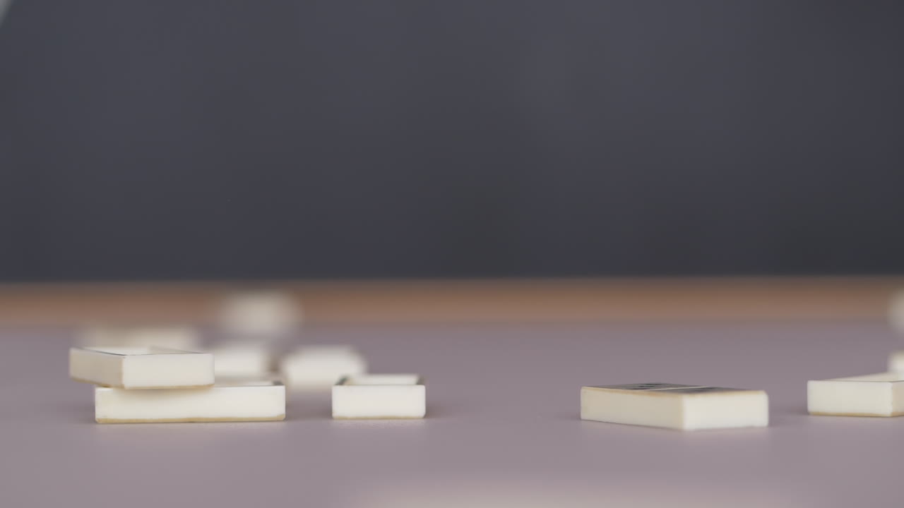 piezas de dominó blancas cayendo sobre la mesa