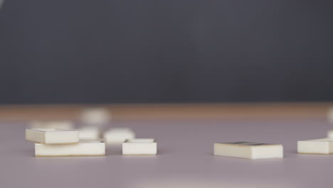 White-domino-pieces-falling-onto-table