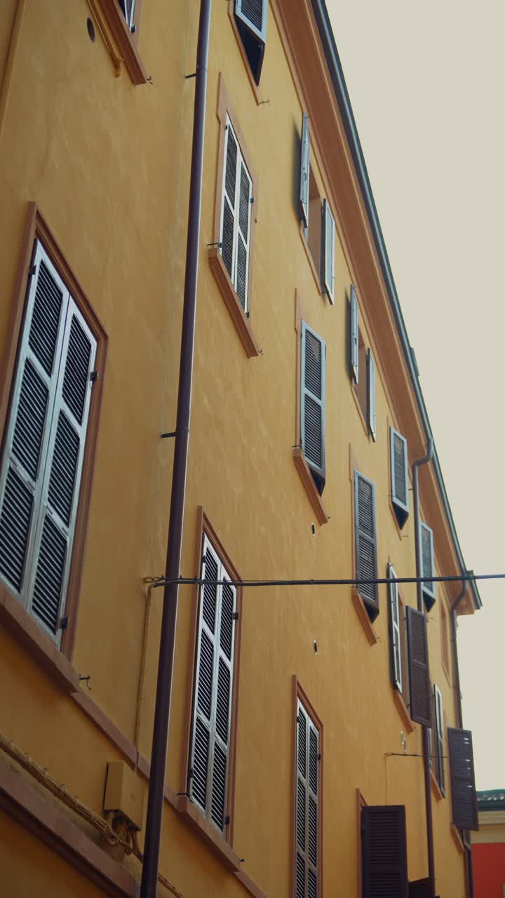 Facade of a building with shutters in a narrow street