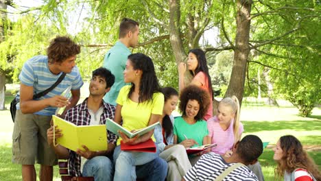 cheerful students reading and chatting together outside on campus