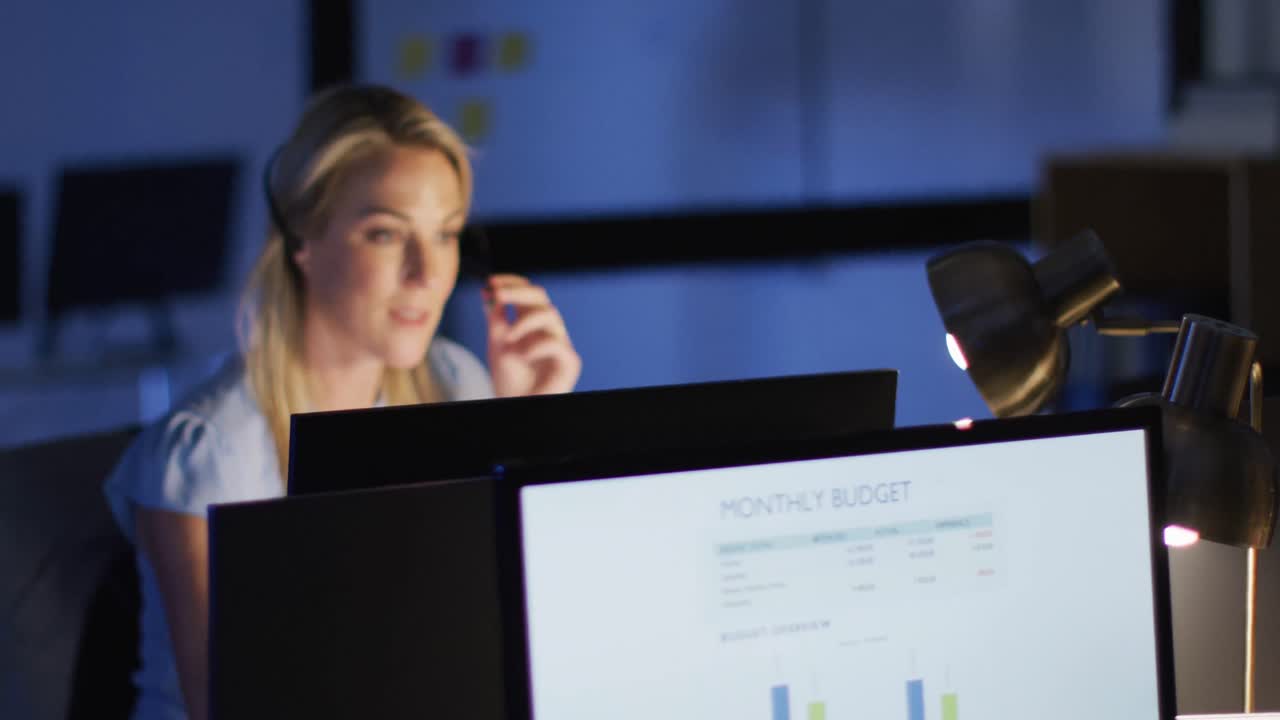 Video of happy caucasian female consultant working late in office
