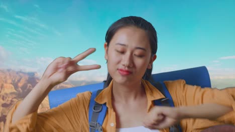close up of asian female hiker with mountaineering backpack enjoy dancing while traveling at the top of mountain