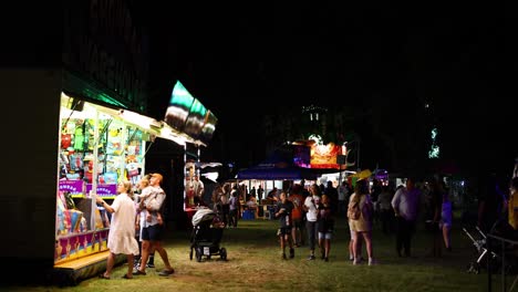 people enjoying games at a night fair