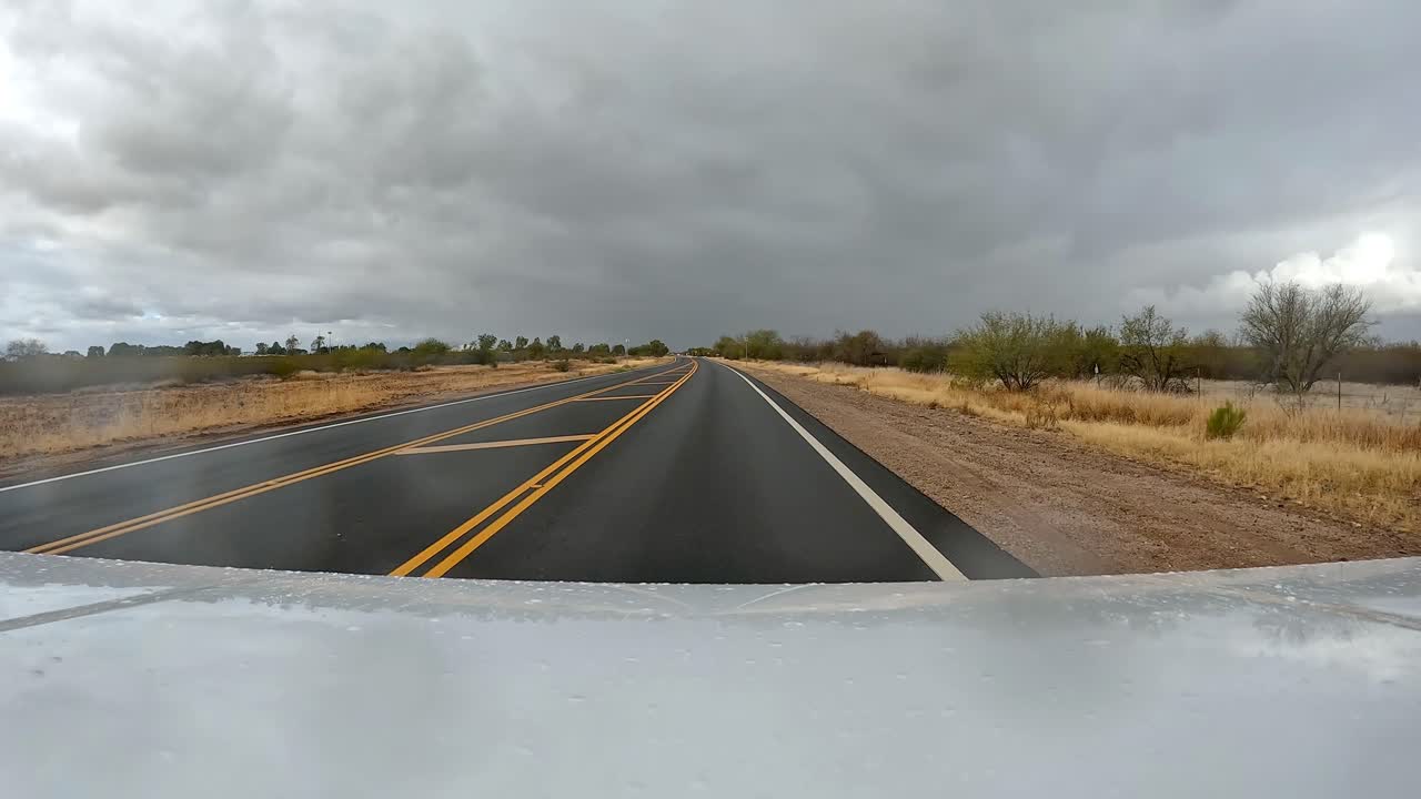 punto de vista - conduciendo en una carretera rural en el desierto de sonora en un día nublado y lluvioso en arizona