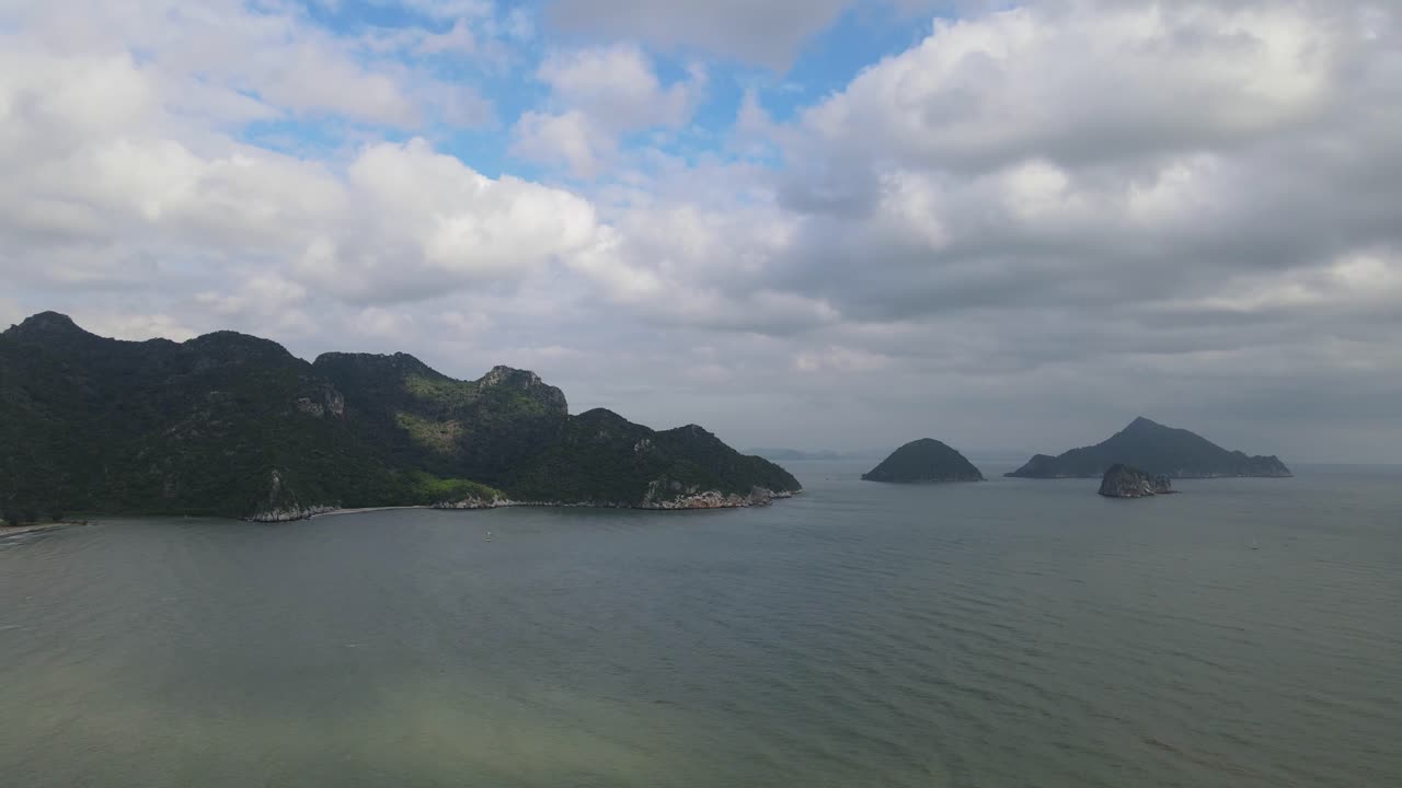 푸른 하늘, 보송보송한 흰색과 회색 구름, 물과 햇빛에 그림자가 있는 맑은 날 동안 항공 영상 역방향