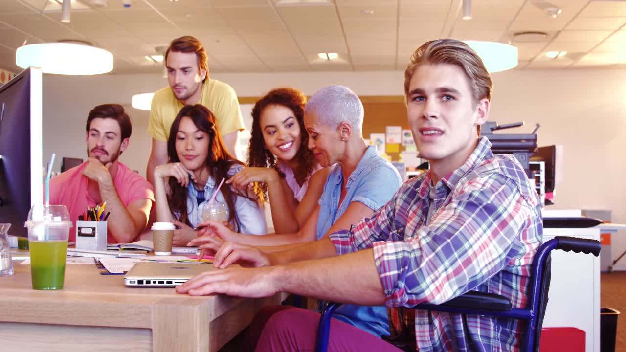 개인용 컴퓨터에서 토론을 하는 동료들