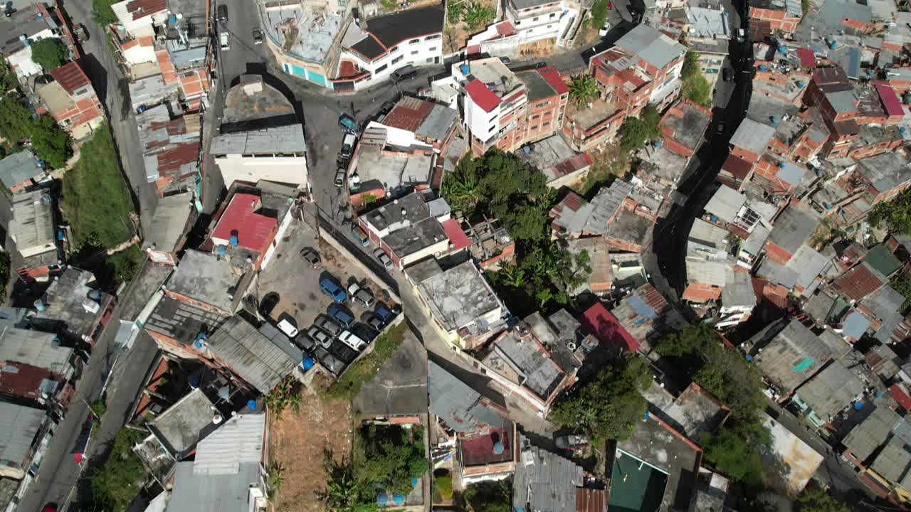 Tilt up drone view of Petare rooftops and streets in sunny Miranda, Venezuela