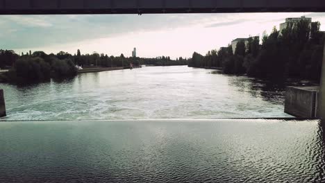 flying-through-a-floodgate-in-Frankfurt-am-Main-Germany,-tilting-camera-down