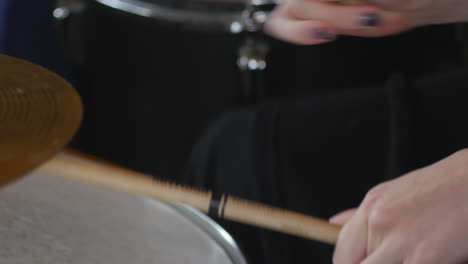 sticks blur as drummer twirls them through fingers while playing drums