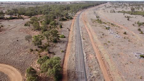 Drohne-Fliegt-über-Eine-Eisenbahnlinie-In-Einer-Wüstenlandschaft