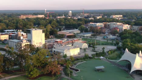 drone shot over a park approaching an apartment complex, panning up to the sky