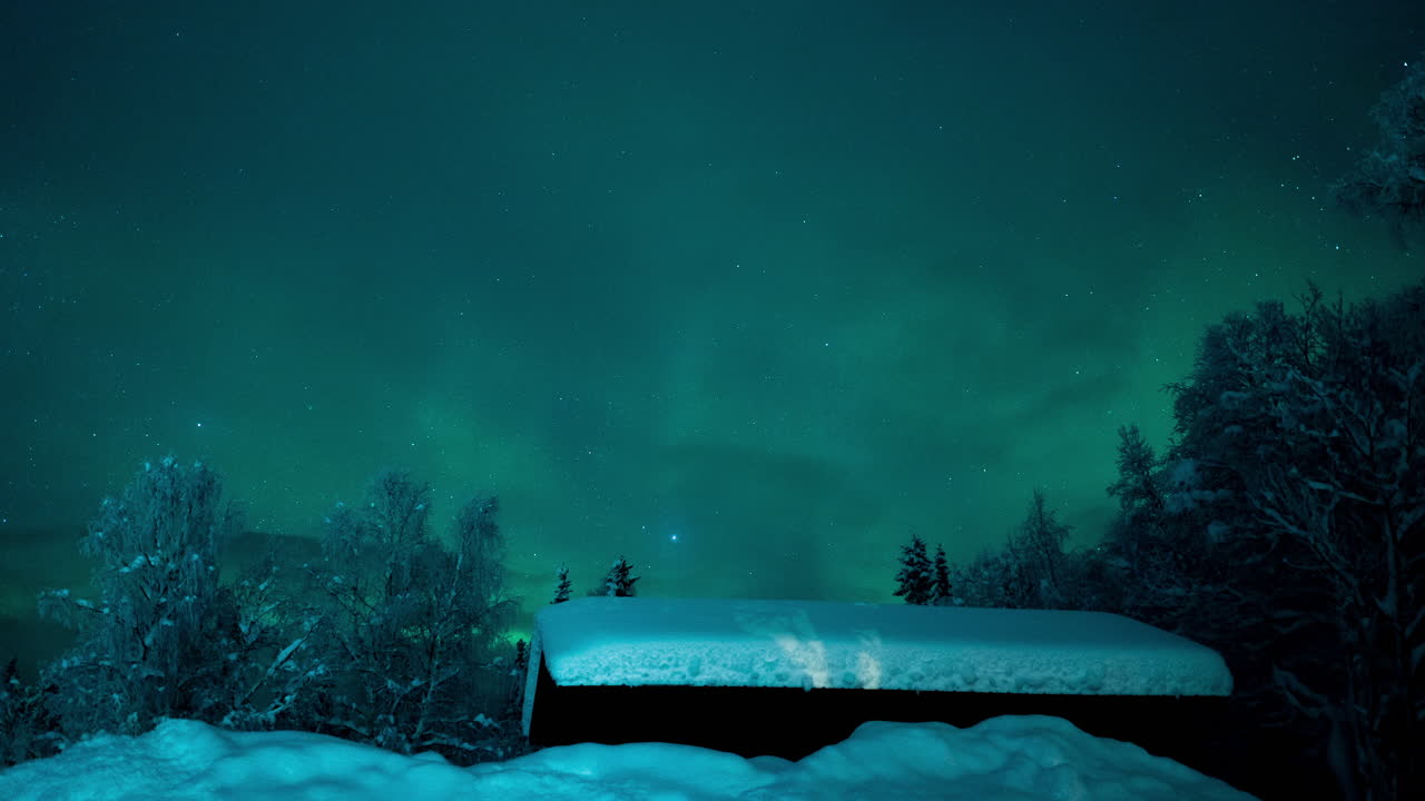 la aurora boreal flotando sobre una cabaña de troncos cubierta de nieve bajo las estrellas en el norte de suecia