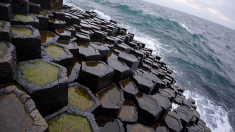 ocean waves crashing on hexagonal basalt rock formations