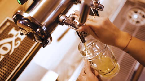 bartender filling up with a blonde craft beer into a pint glass