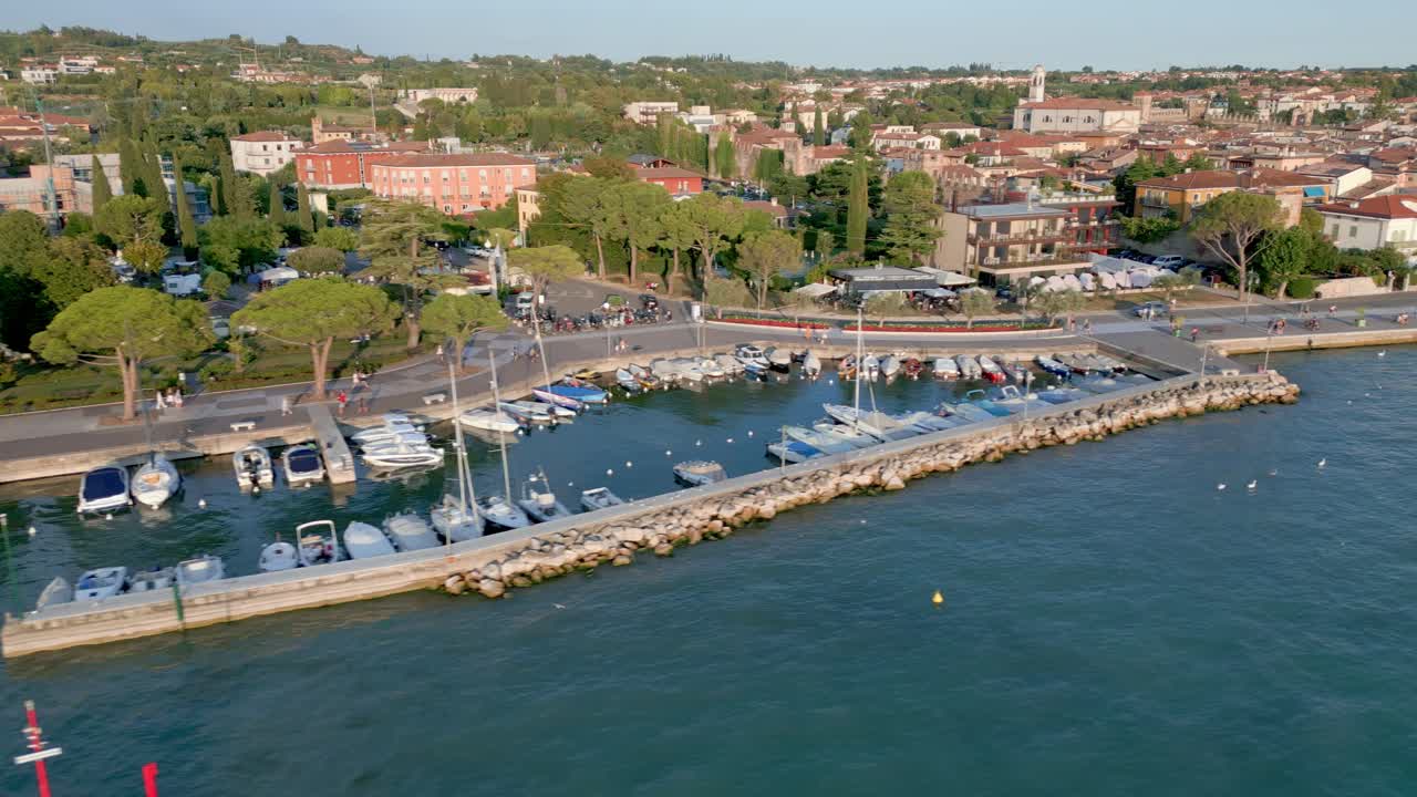 los barcos están en una alcoba protectora con la hermosa ciudad de lazise al fondo