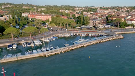 Boats-are-mored-in-a-protective-alcove-with-the-beautiful-town-of-Lazise-in-the-background