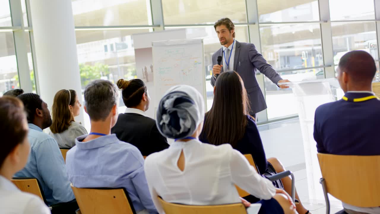 orador masculino con clipboard hablando en el seminario de negocios 4k