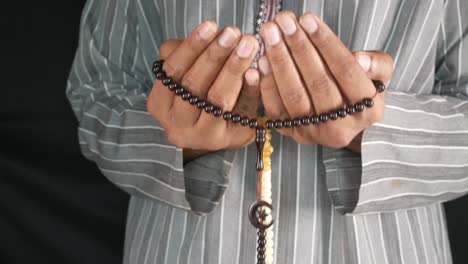hombre musulmán orando con cuentas de oración
