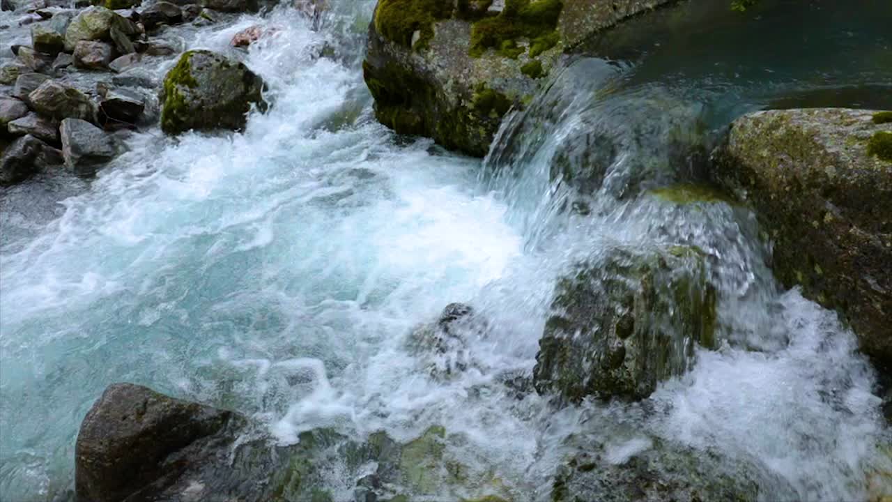 Acqua di fiume di montagna con primo piano al rallentatore.