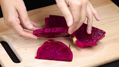 hands slicing and peeling vibrant dragon fruit