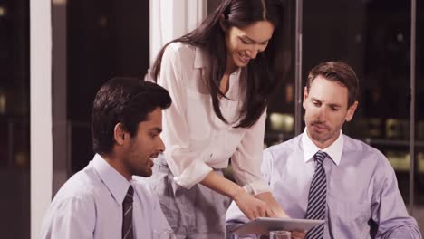 Businesswoman-discussing-with-colleagues-over-digital-tablet