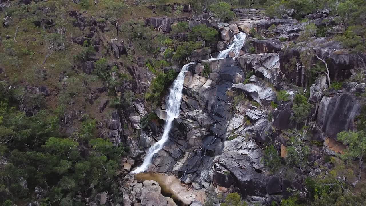 agua que fluye y salpica en las rocas junto a las cataratas davies creek en queensland, australia